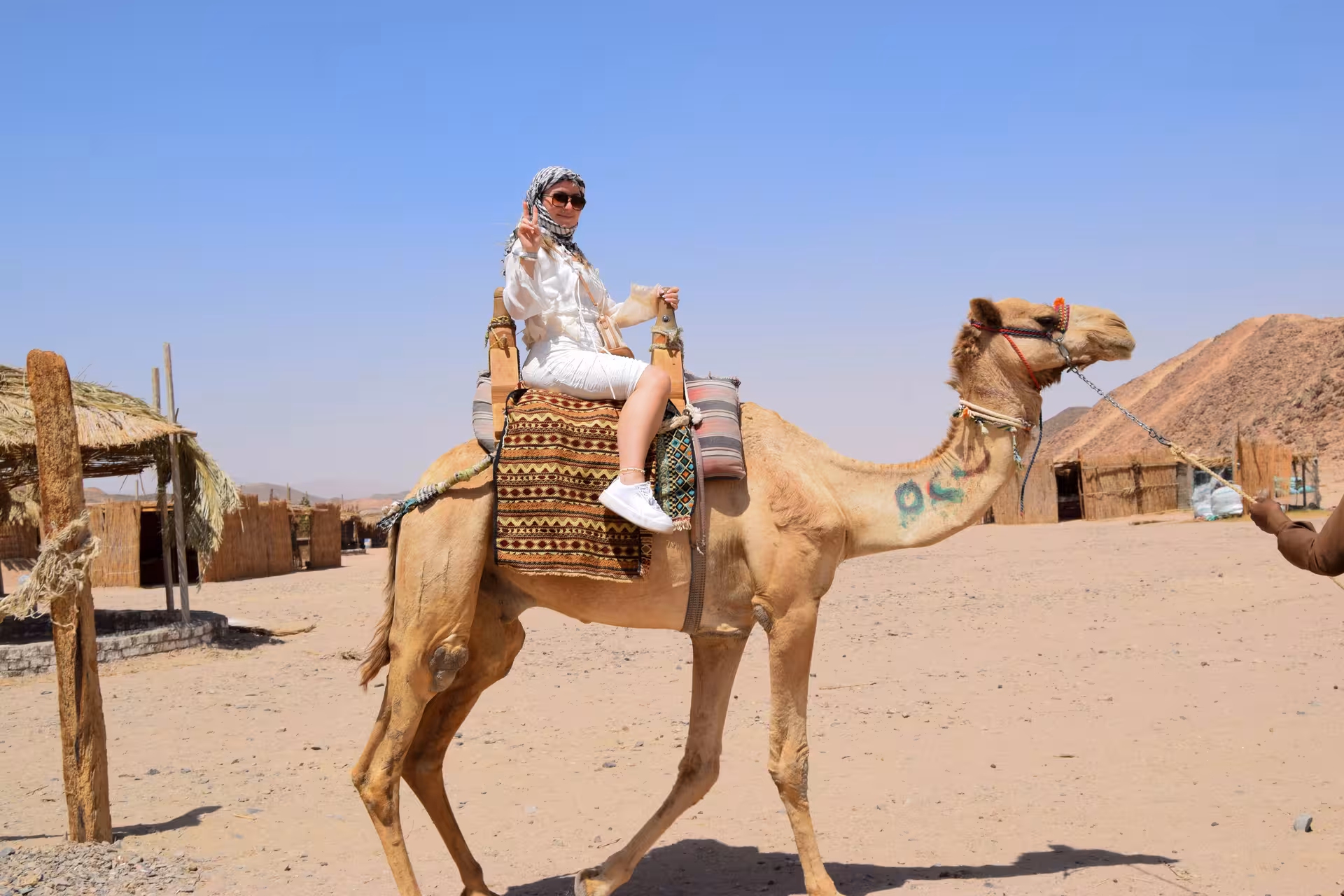 Tourist on camel ride at Bedouin village in Hurghada desert, part of ATV quad safari excursion