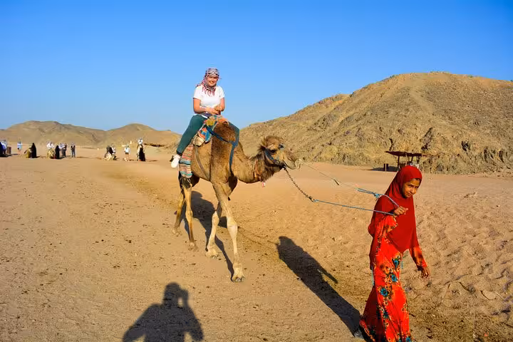 Tourist enjoying camel ride in Hurghada desert during 3-hour quad bike safari tour with Bedouin guide