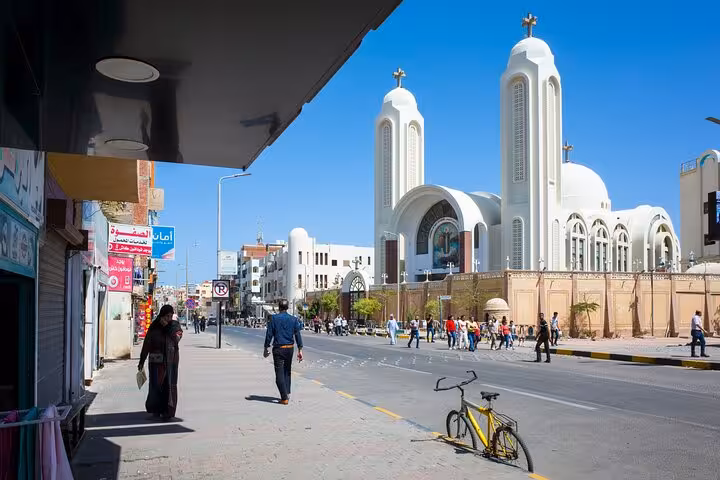 Hurghada city guided tour street view with Coptic church and local shops on a sunny day