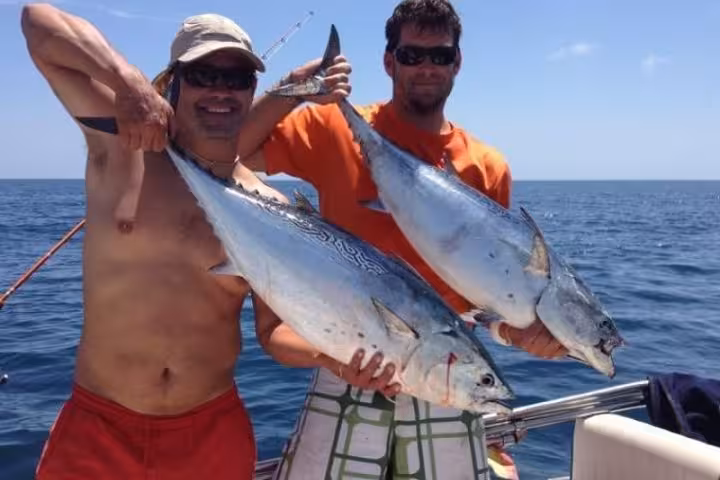 Anglers holding big tuna on a Red Sea boat, deep sea fishing tour from Hurghada with catch of the day