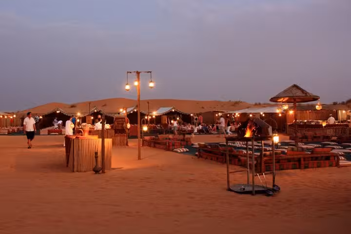 Hurghada desert Bedouin camp at dusk with lanterns, fire pit and dinner setup for jeep safari stargazing