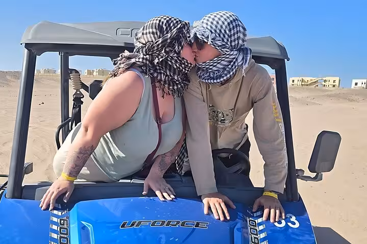 Couple in a Hurghada desert buggy wearing scarves during an ATV and buggy adventure by sea and mountains