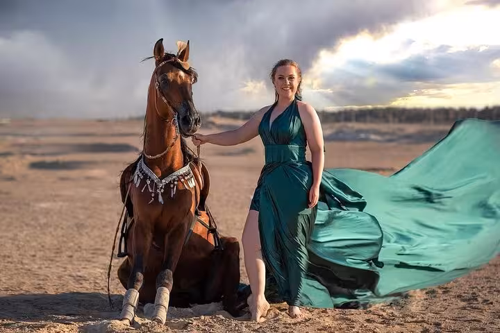 Guest poses with horse in Hurghada desert at sunset, part of Desert & Sea Horse Riding Tour experience