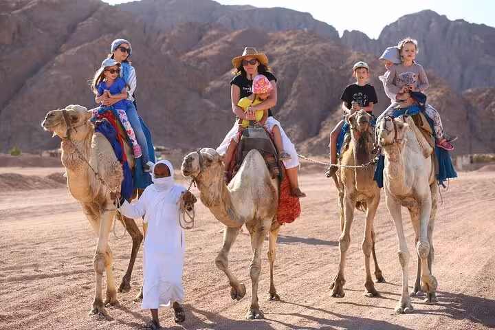 Families on camel safari in Hurghada desert, part of quad bike ATV tour with BBQ dinner and transfer