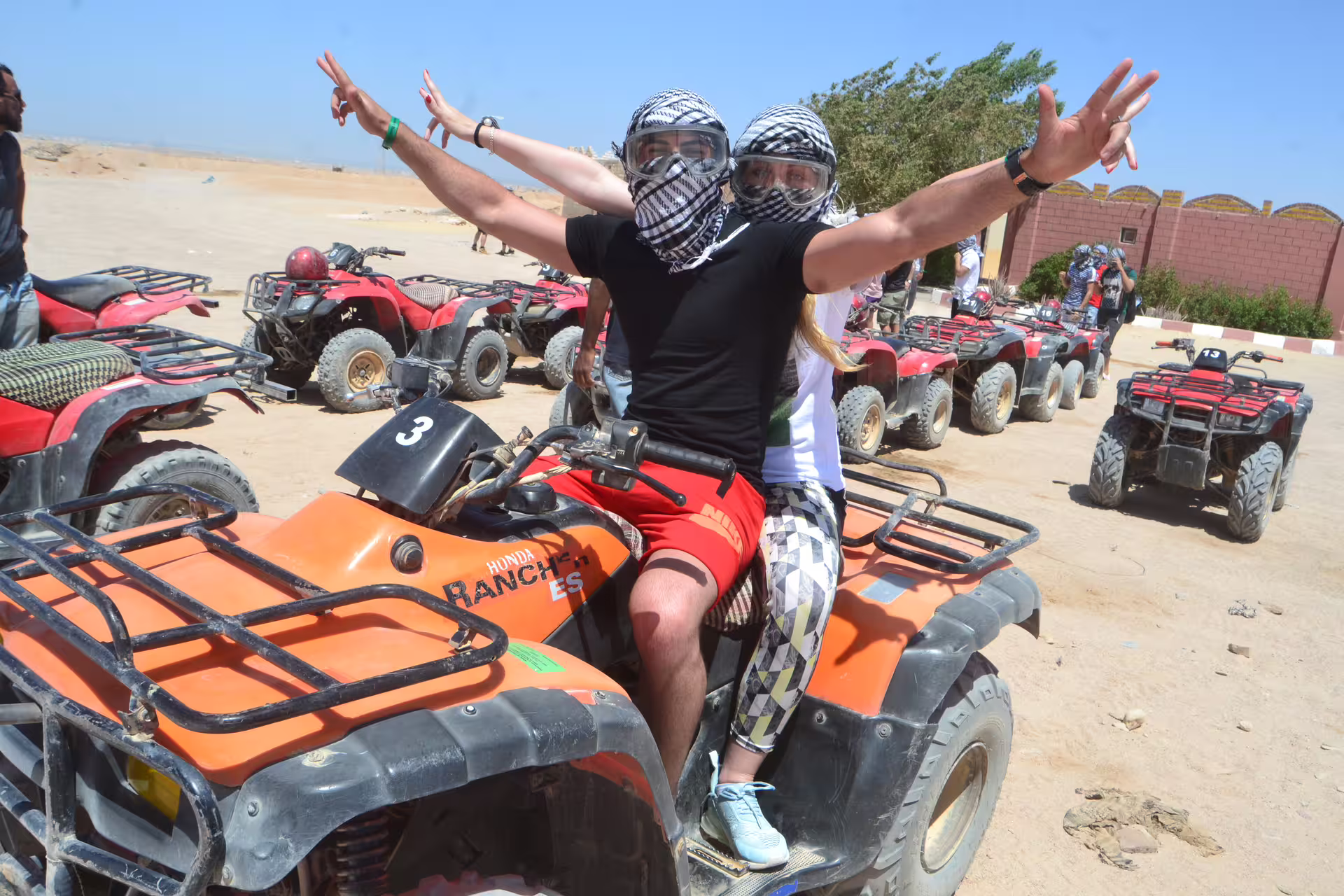 Couple on quad bike in Hurghada desert, keffiyeh and goggles, Mega Safari ATV adventure tour