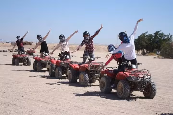 Group riding ATVs in Hurghada desert safari, quad bike adventure with BBQ dinner and roundtrip transfer