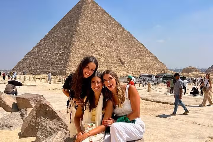 Friends smiling at the Great Pyramid of Giza on a Hurghada small group tour to Cairo and the Grand Egyptian Museum