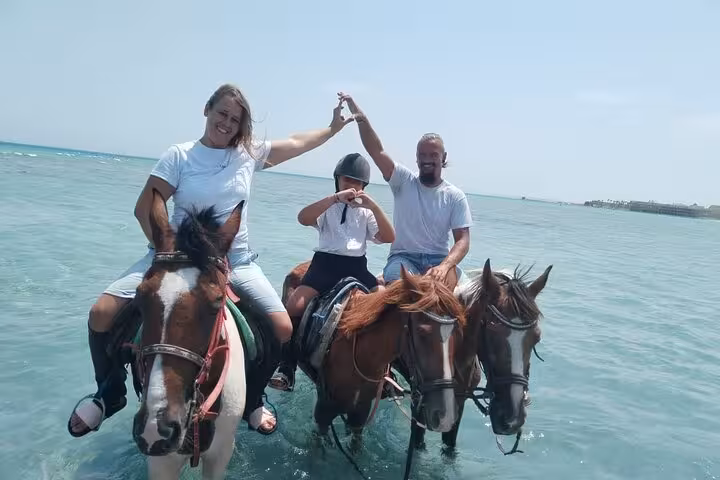 Family horse riding in the Red Sea at Hurghada, shallow turquoise water, desert & sea tour with swimming option