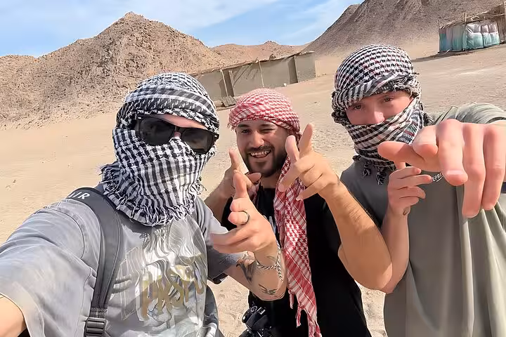 Friends in keffiyeh scarves posing in Hurghada desert on 6-hour jeep safari with BBQ dinner and show