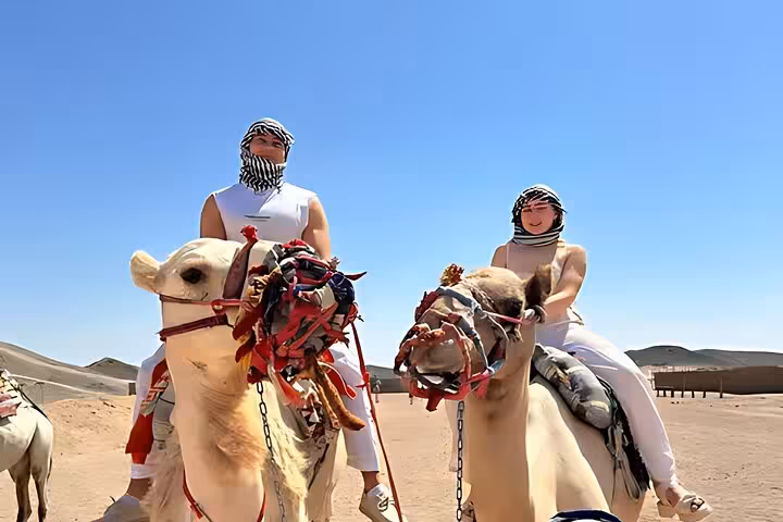 Tourists riding camels in Hurghada desert during 6-hour Jeep safari, Bedouin-style adventure and BBQ dinner