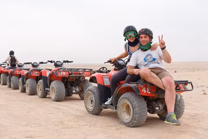 Tourists on quad bikes in Hurghada desert convoy, included in 6-hour jeep safari with BBQ dinner and show