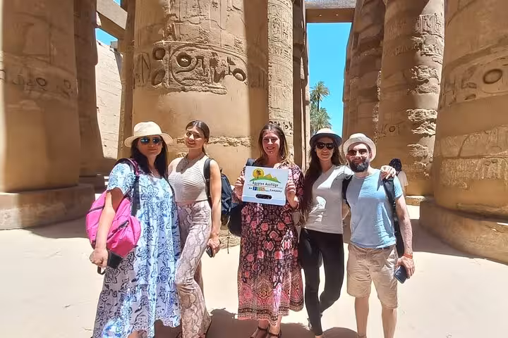 Tour group between Karnak Temple columns on Hurghada to Luxor excursion, Valley of the Kings and Tutankhamun tomb