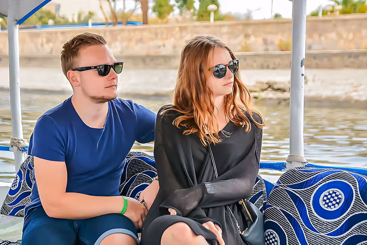 Couple relaxing on Nile felucca boat ride in Luxor, part of Hurghada day trip to Valley of the Kings tour