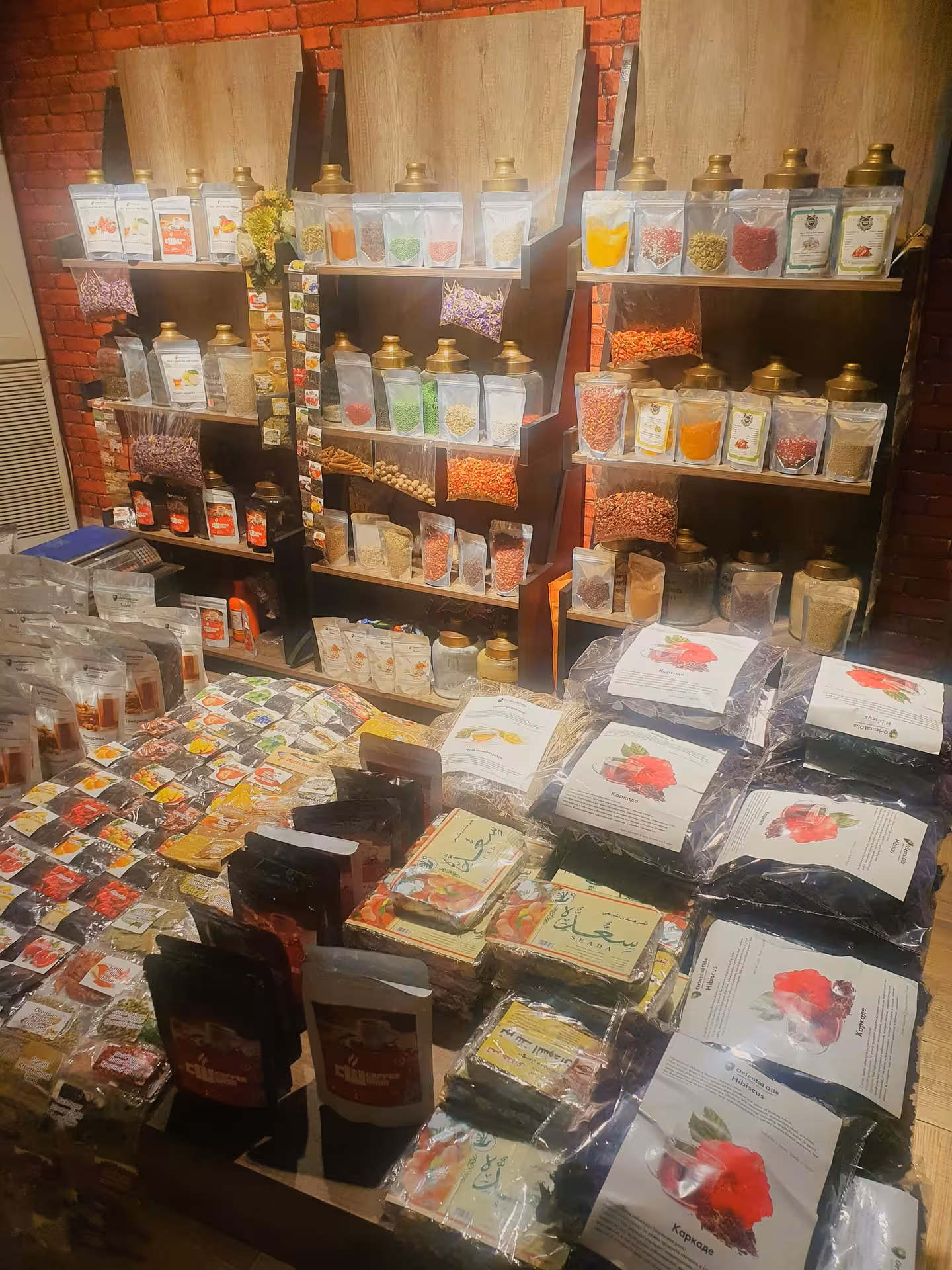 Colorful spices, herbs, and hibiscus tea packets displayed on shelves at Hurghada market stall