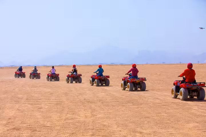 ATV quad bike convoy crossing Hurghada desert on guided super quad safari, before dinner, show and shopping stop