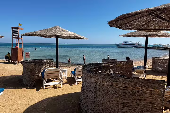 Hurghada Red Sea beach with sun loungers and straw umbrellas, relaxing stop on 10-day Egypt tour