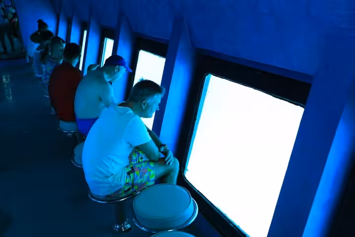 Passengers watch Red Sea marine life through panoramic windows on Hurghada semi-submersible submarine tour