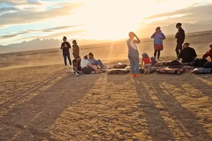 Guests relax on desert cushions at sunset on Hurghada stargazing safari with jeep ride and optional ATV
