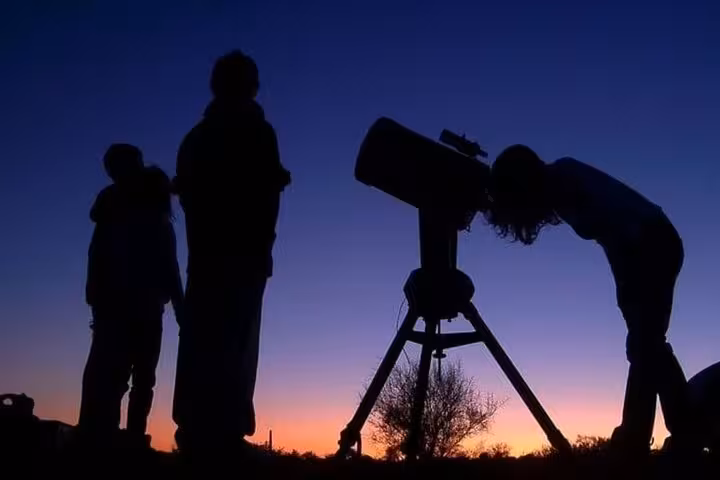 Guests stargaze with telescope at desert sunset on Hurghada jeep safari, with optional ATV ride