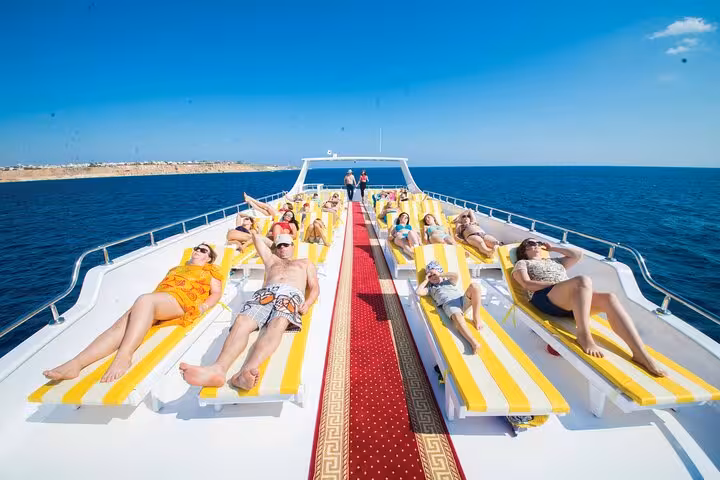 Sunbathers relax on the top deck of a Hurghada elite VIP cruise yacht sailing the Red Sea