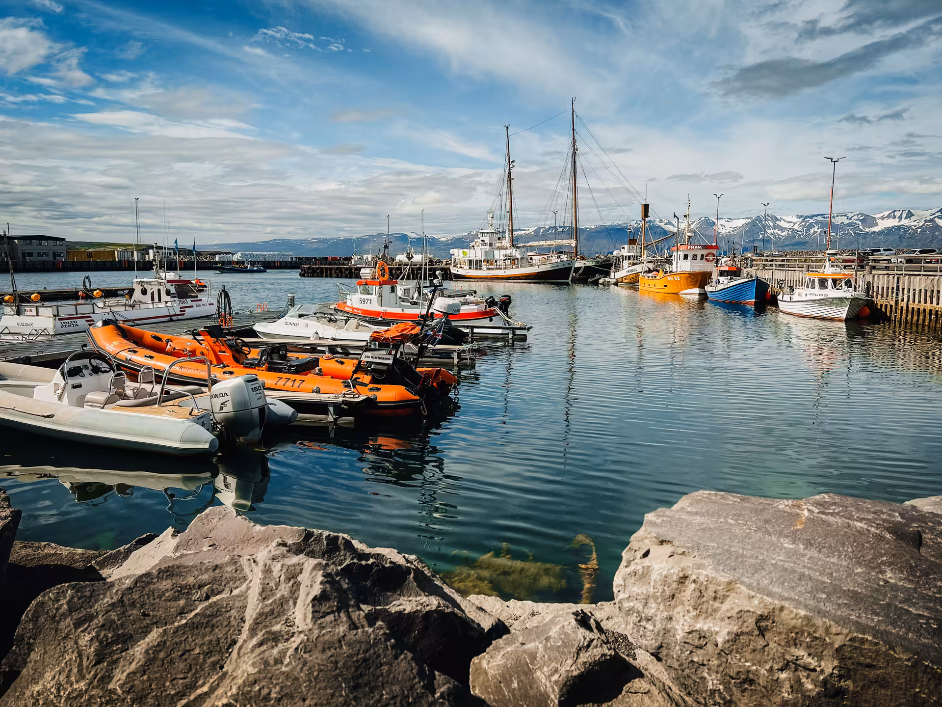 Husavik harbor boats and mountains, scenic stop on Iceland Private Adventure Diamond Circle Tour from Akureyri