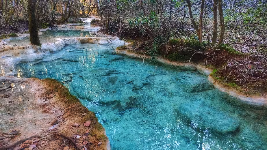 Turquoise spring-fed pools at the Huveaune River source, scenic Provence hike through time, nature and cascades