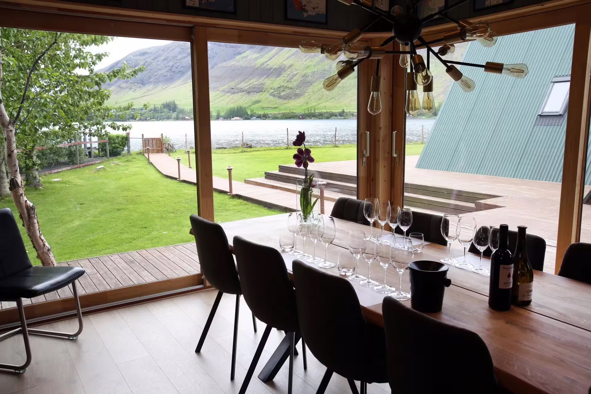Elegant hidden fjord lodge dining area with wine glasses and breathtaking fjord and mountain views