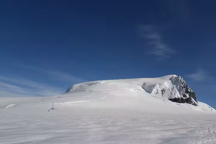 Snow-covered Hvannadalshnjukur glacier summit under clear blue sky in Iceland