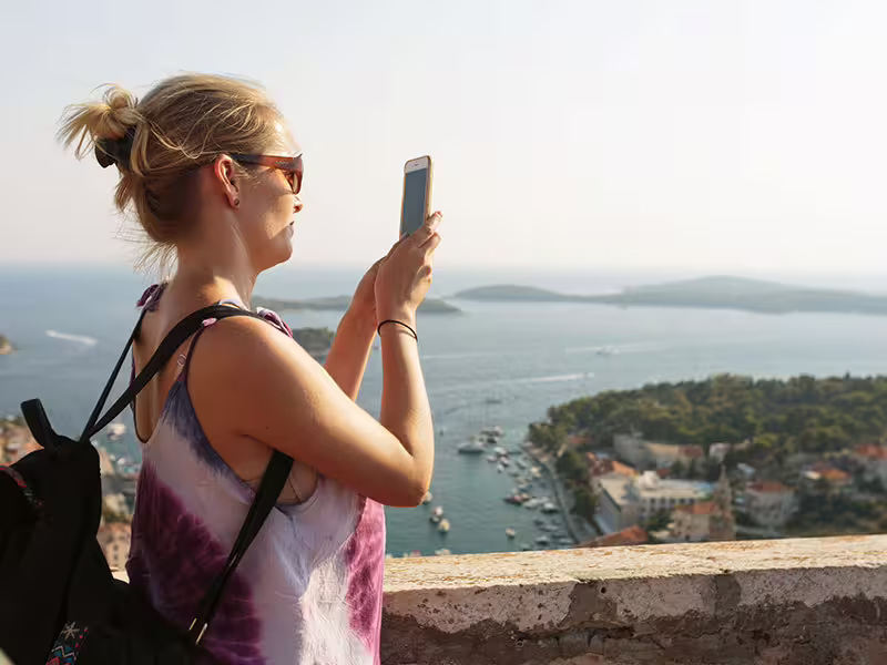 Traveler photographing Hvar islands viewpoint above Adriatic, perfect moment on Hvar Brac Solta private boat tour