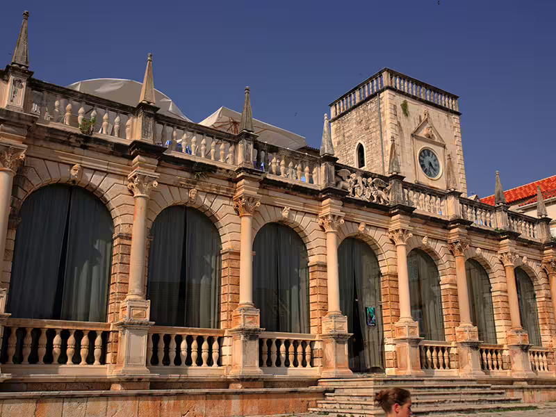 Historic Hvar Town stone arcade and clock tower, a cultural stop on a private boat tour from Split