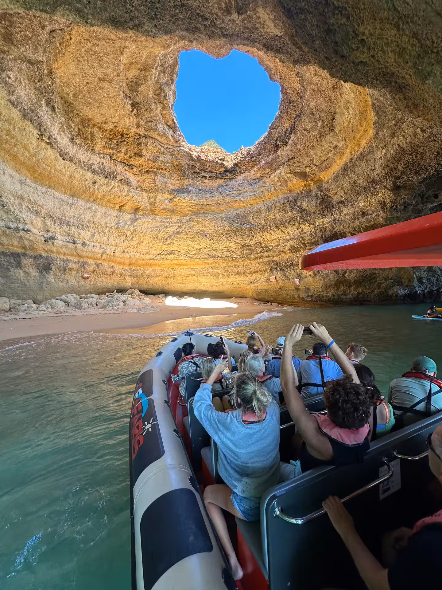 Tourists on a Seafaris boat tour exploring the iconic Benagil Cave sea arch from Lagos, Algarve Portugal
