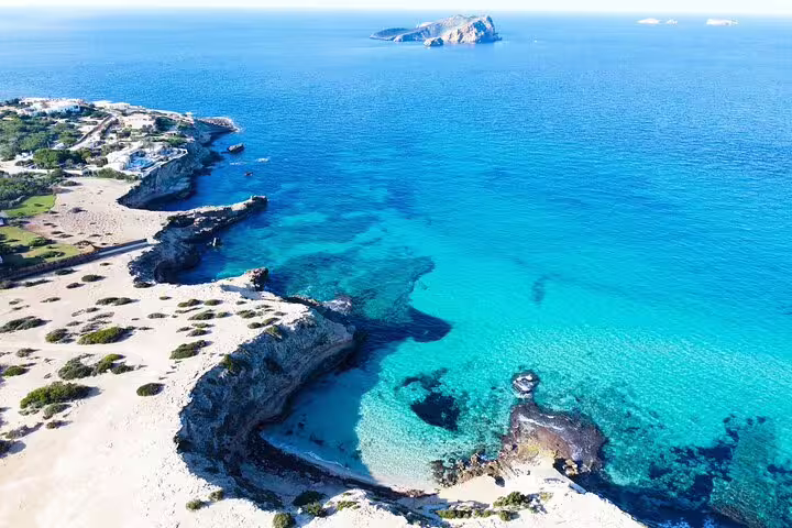 Ibiza coastline near Cala Comte with crystal-clear water and rocky coves, route on guided jet ski tour