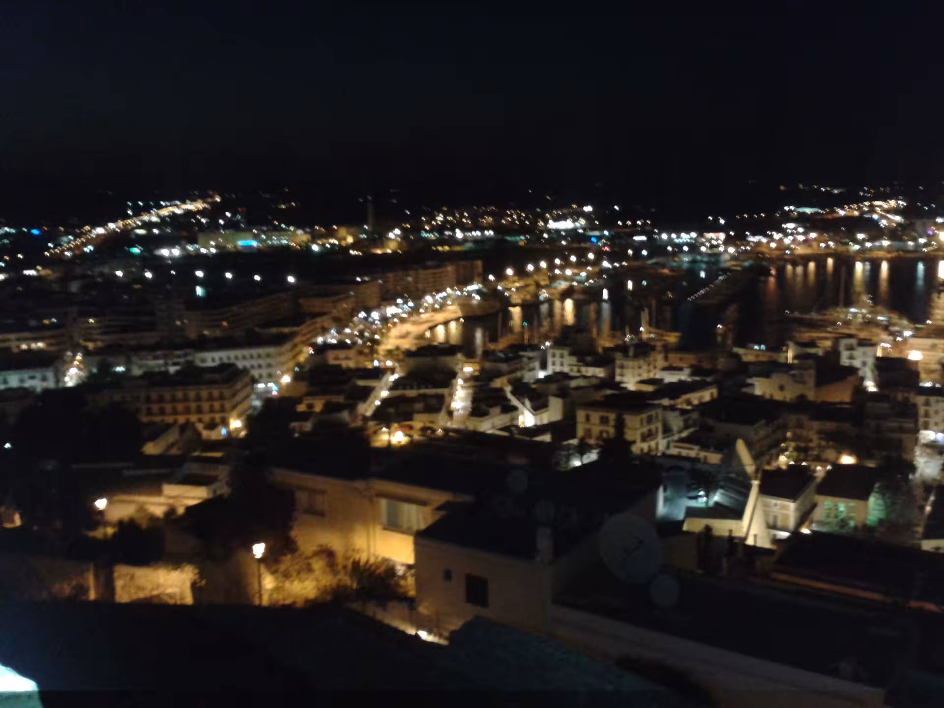 Night view over Ibiza Town and marina lights from Dalt Vila walls during official guided evening tour