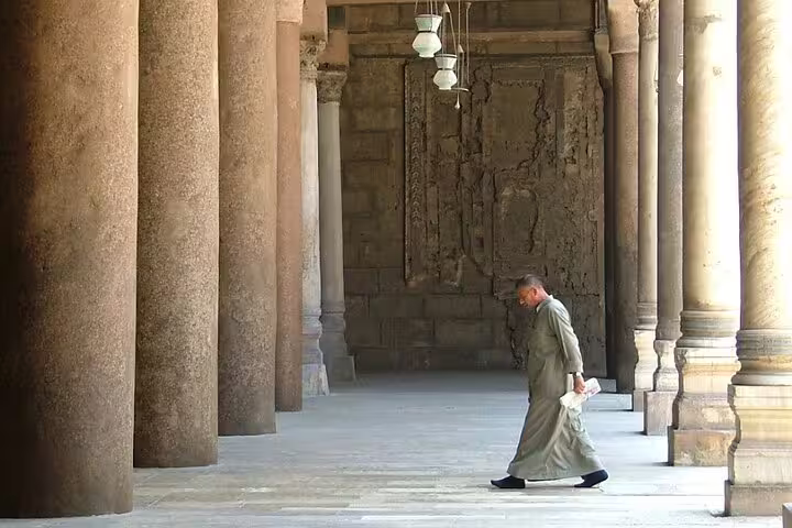 Walking through Ibn Tulun Mosque courtyard colonnade in Islamic Cairo on a Historical Cairo Mosques guided tour