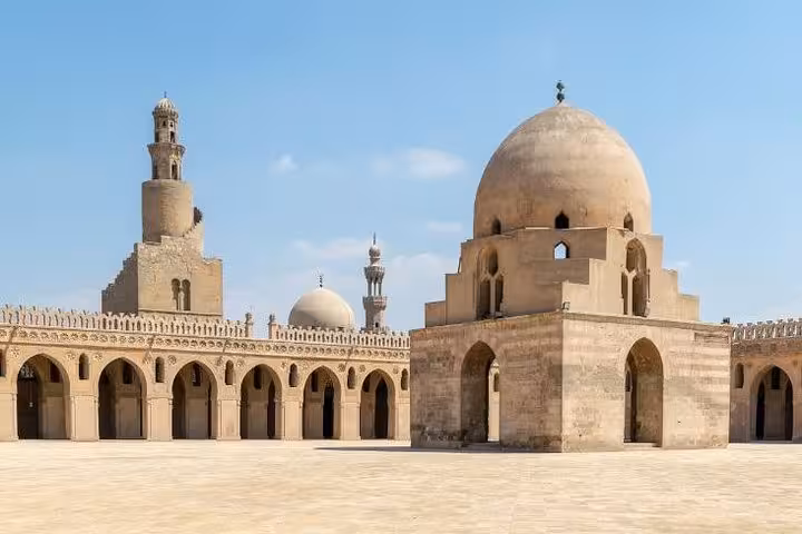 Sunlit courtyard and domes of Ibn Tulun Mosque, a highlight of Islamic Cairo hidden gems tour in Egypt