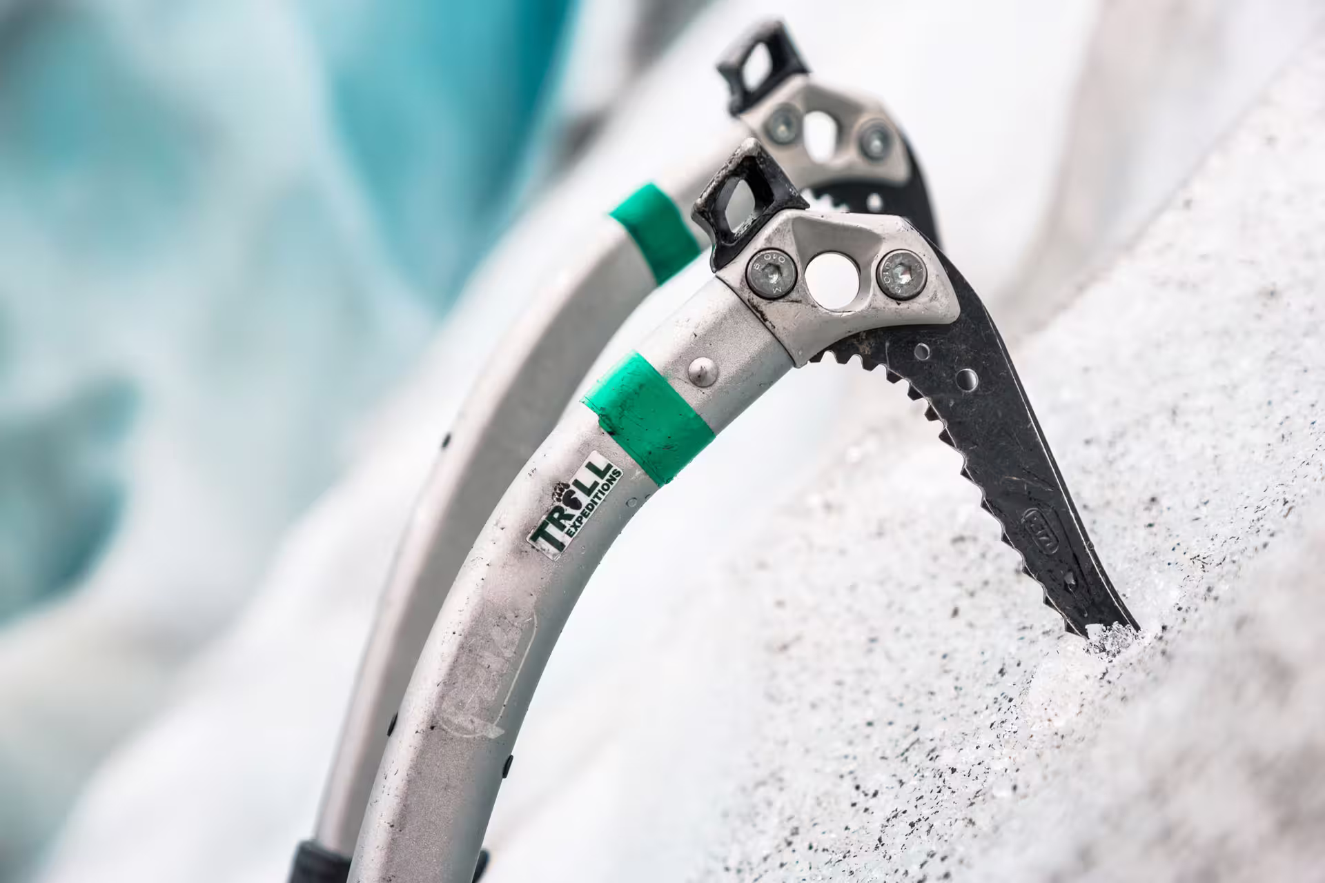 Ice climbing axe with Troll Expeditions branding embedded in glacier ice at Skaftafell