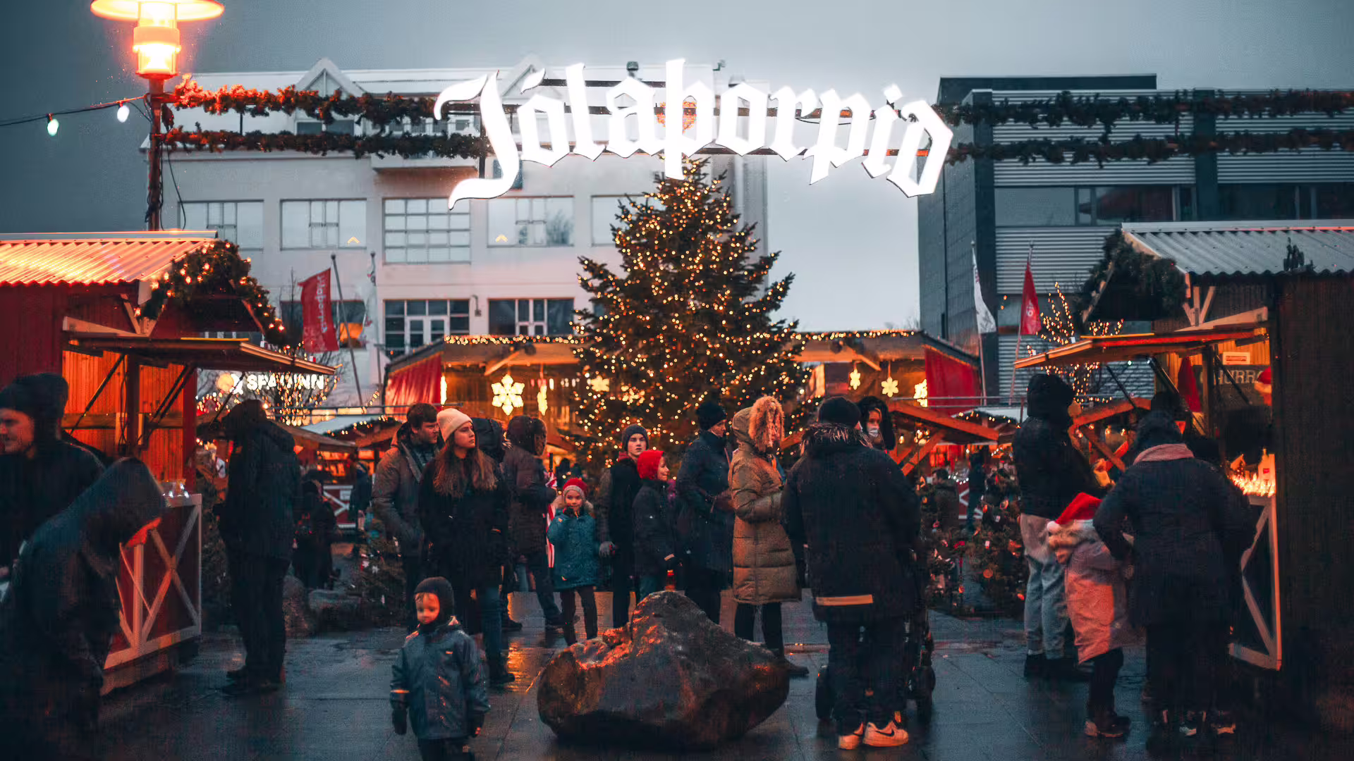 Jólaborðið Christmas market in Iceland with festive wooden stalls, lit Christmas tree, and crowds during Advent season