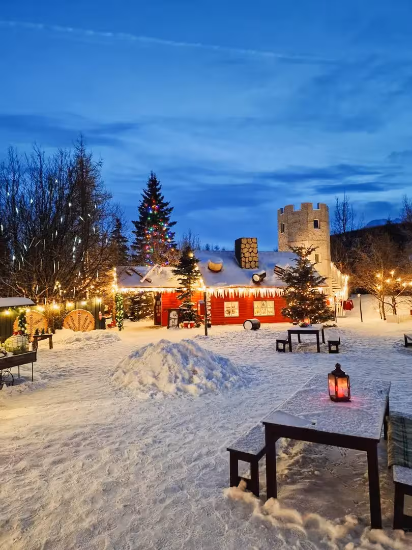 Snowy Christmas village in Iceland with festive lights, cozy cabin and winter market on private adventure tour