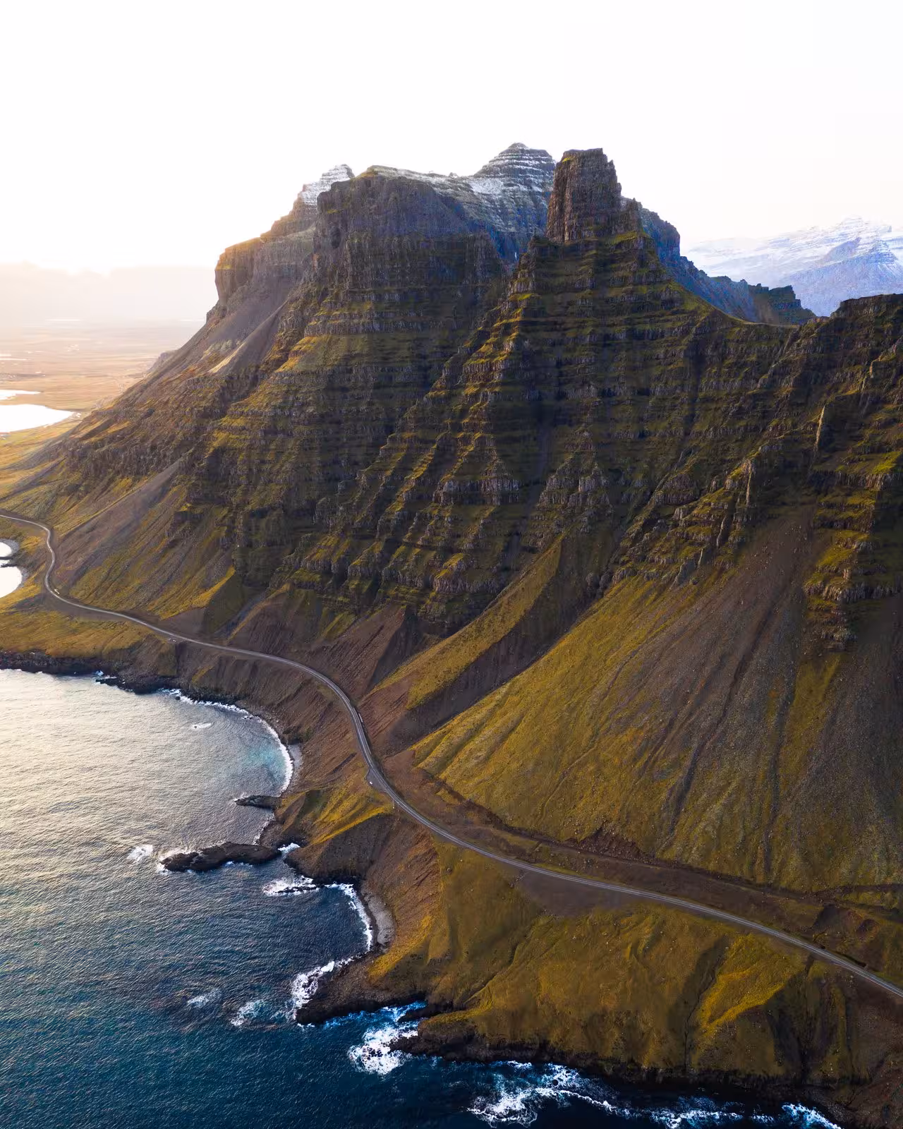 Scenic coastal road winding along dramatic cliffs in Iceland, perfect for exploring on a small group journey.