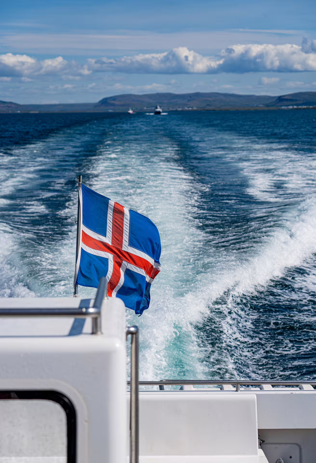 Icelandic flag flying from the stern of a whale watching boat leaving Reykjavik harbour