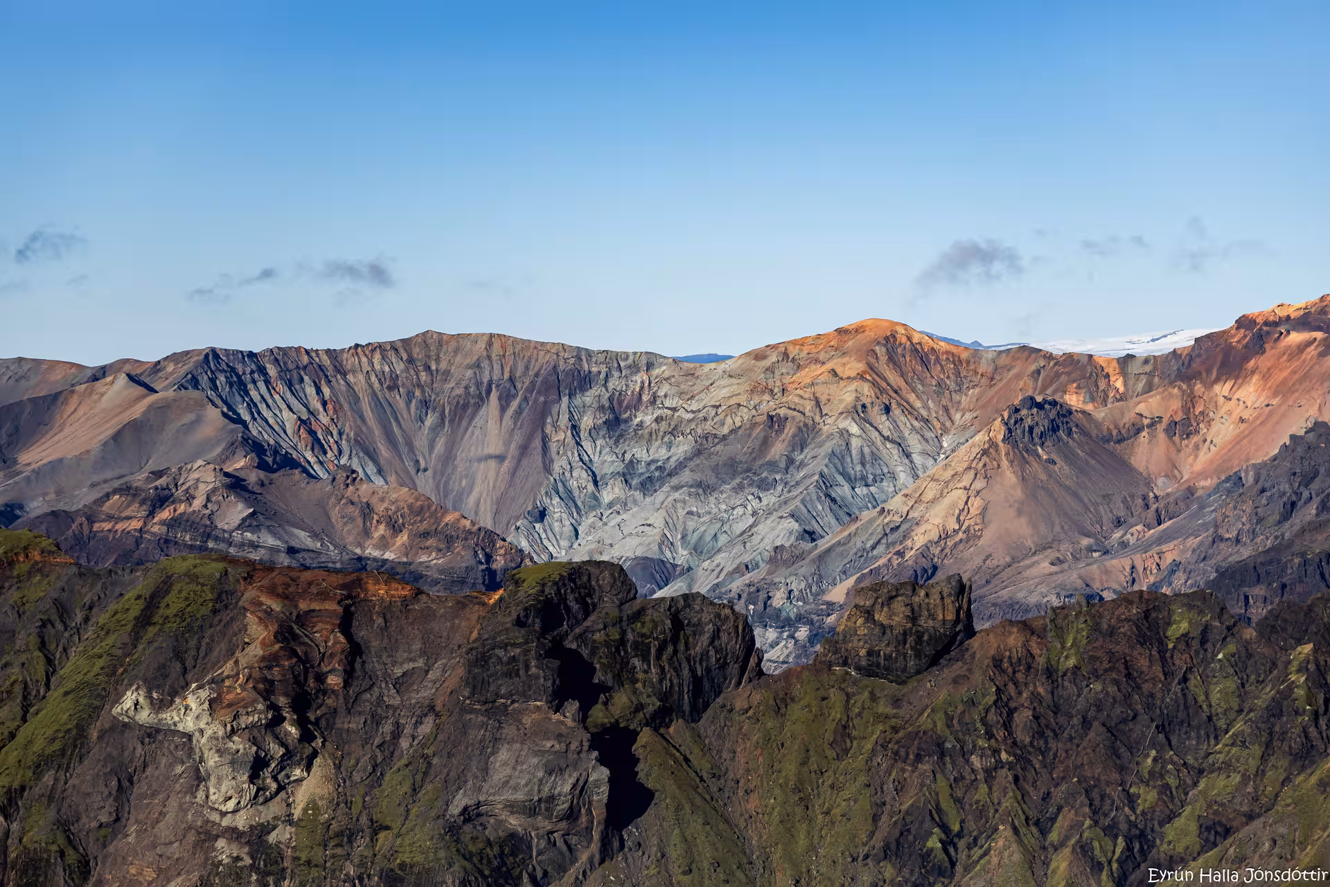 Colorful volcanic mountain landscape in Iceland's highlands with rugged cliffs and glacier visible in background