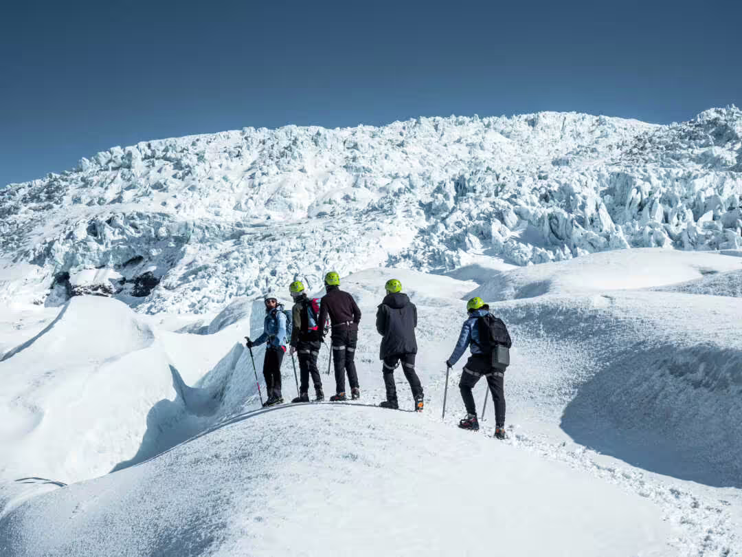 Group of hikers with green helmets exploring a glacier in Iceland on a guided tour
