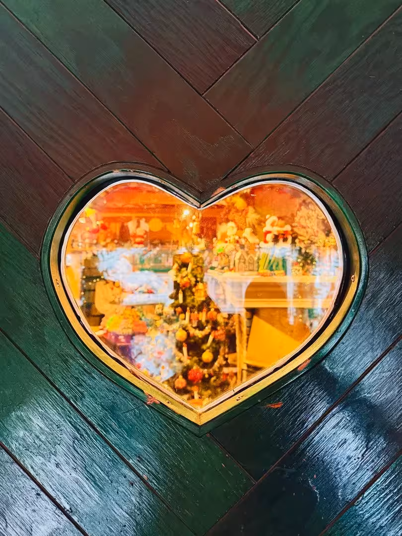 Heart-shaped window glowing with Christmas decor, cozy stop on Sacred Iceland Goðafoss and cacao ceremony tour