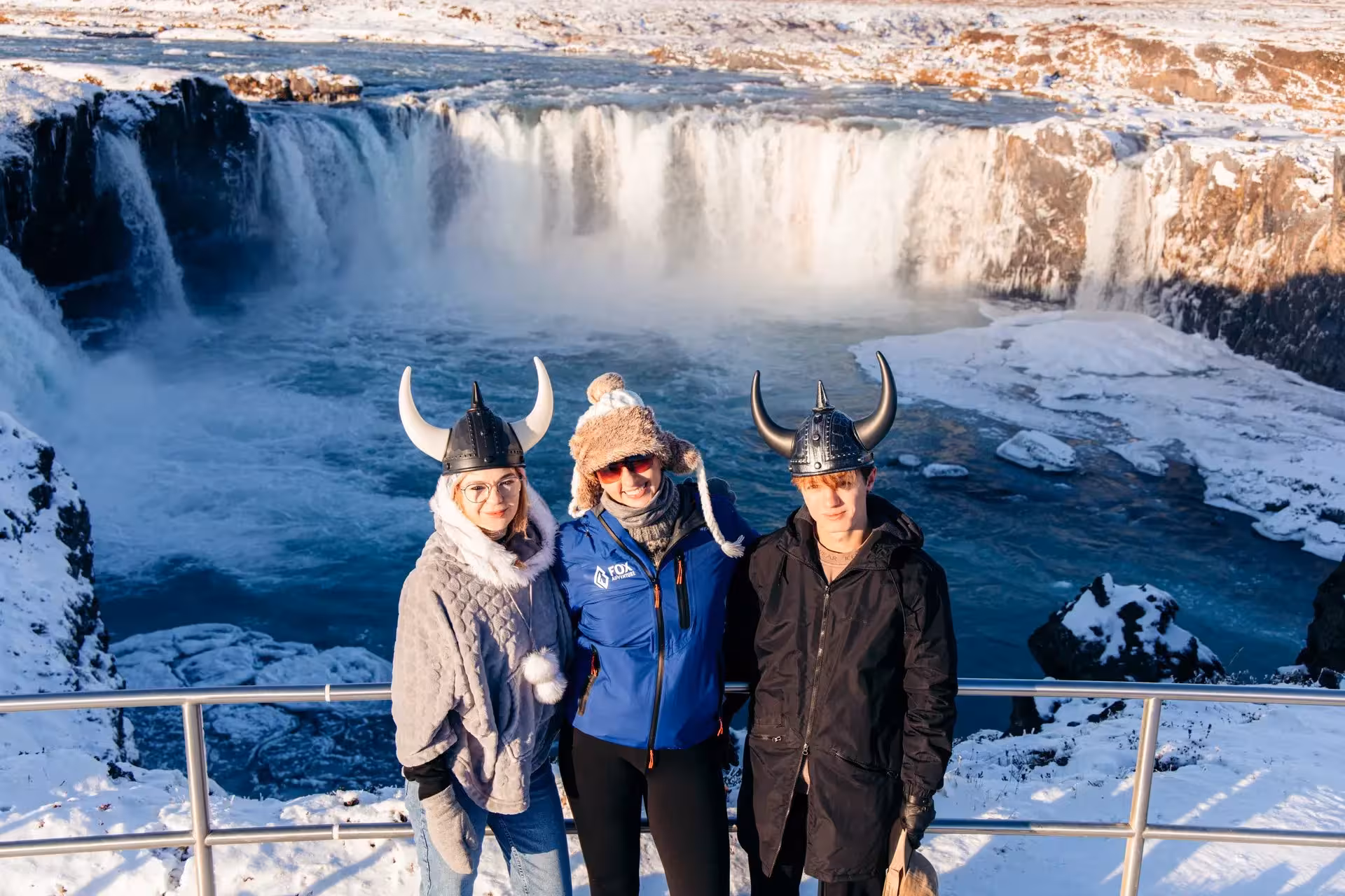 Guests in Viking helmets at Goðafoss Waterfall viewpoint on a private Iceland winter holiday excursion
