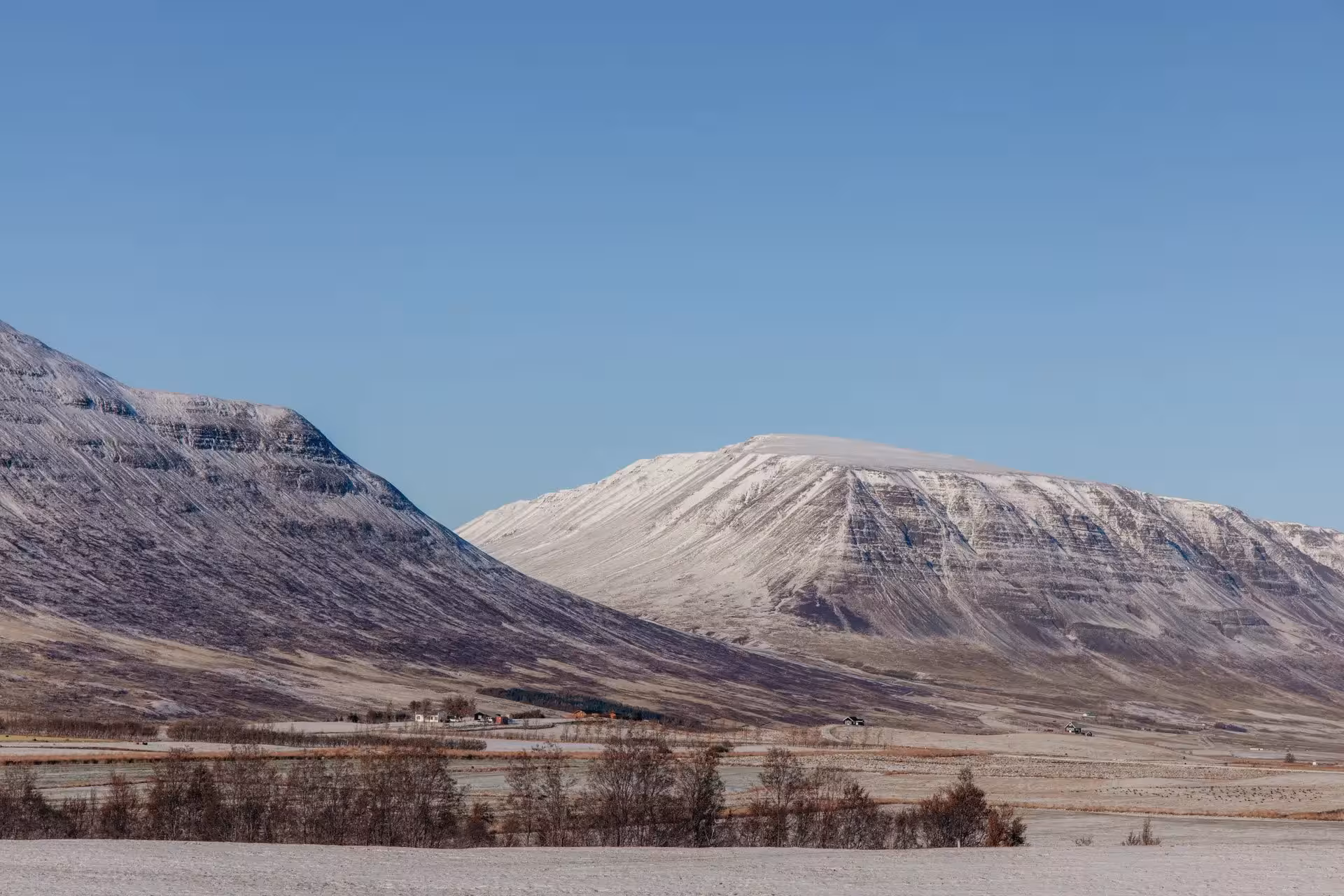 Snow-dusted Icelandic mountains and quiet valley scenery on a private Goðafoss Waterfall winter tour