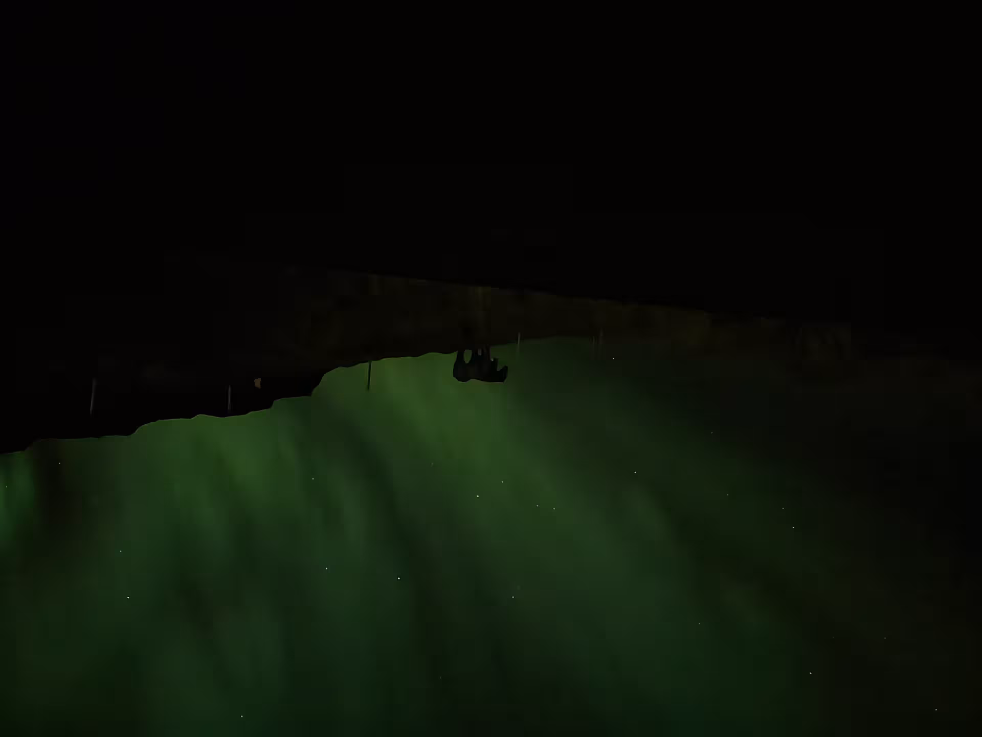 Aurora borealis green northern lights over Iceland landscape at night with rocky overhang silhouette