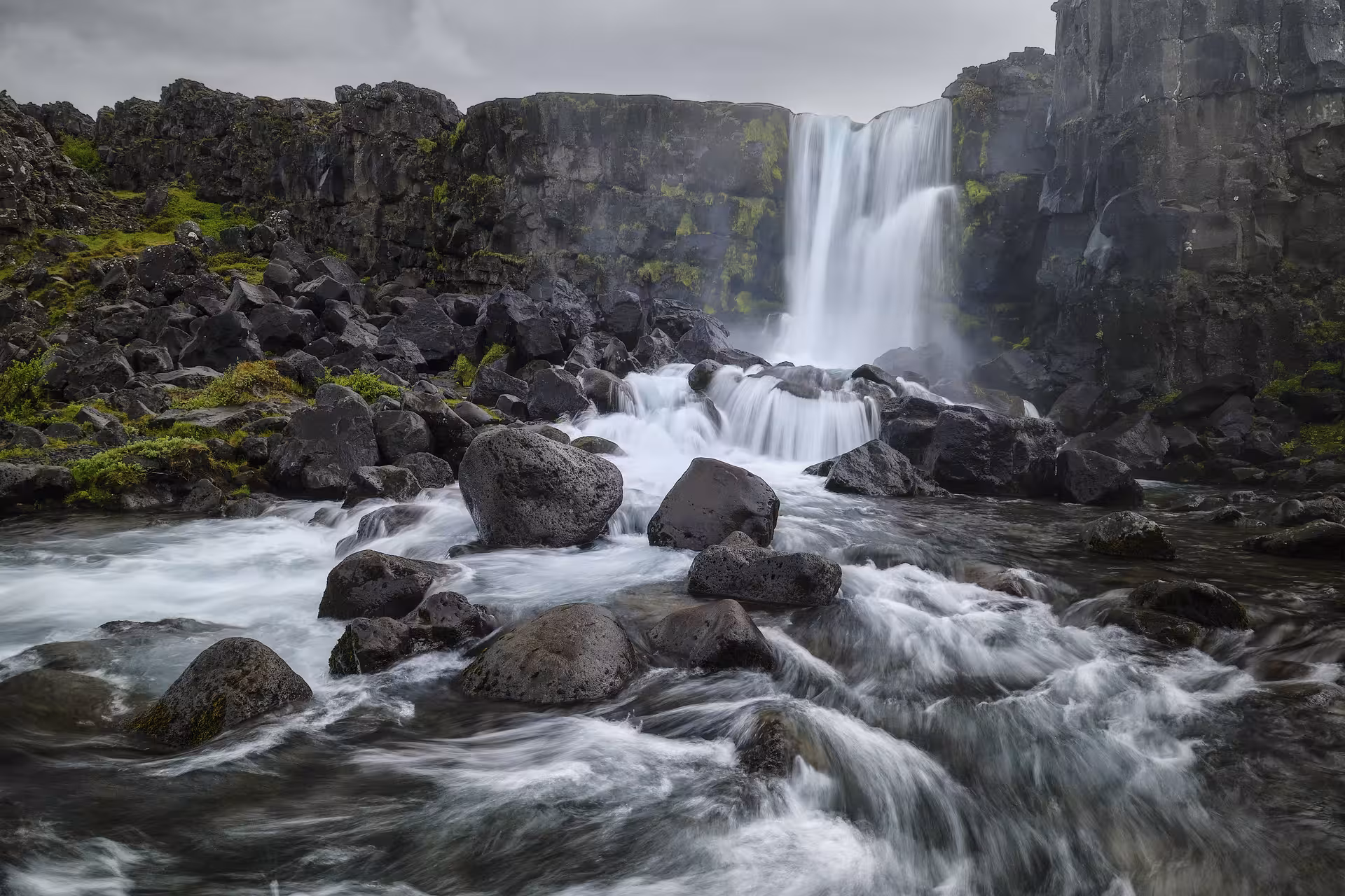 Powerful waterfall cascading over black volcanic rocks in Iceland's Golden Circle landscape
