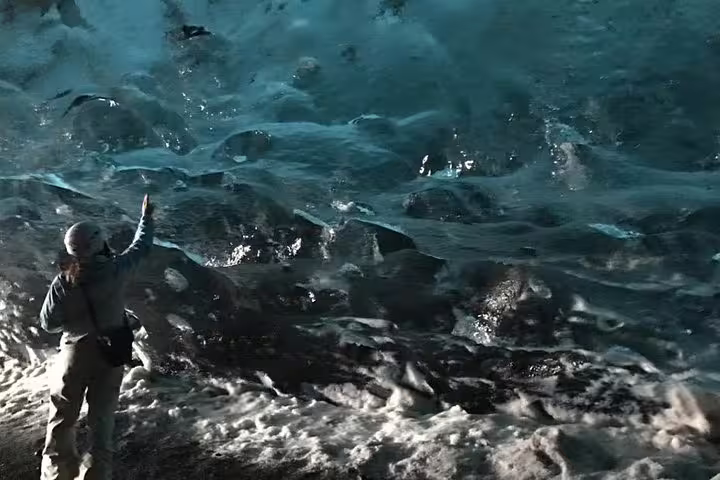 Guide standing at edge of rushing glacial river rapids in Iceland wilderness