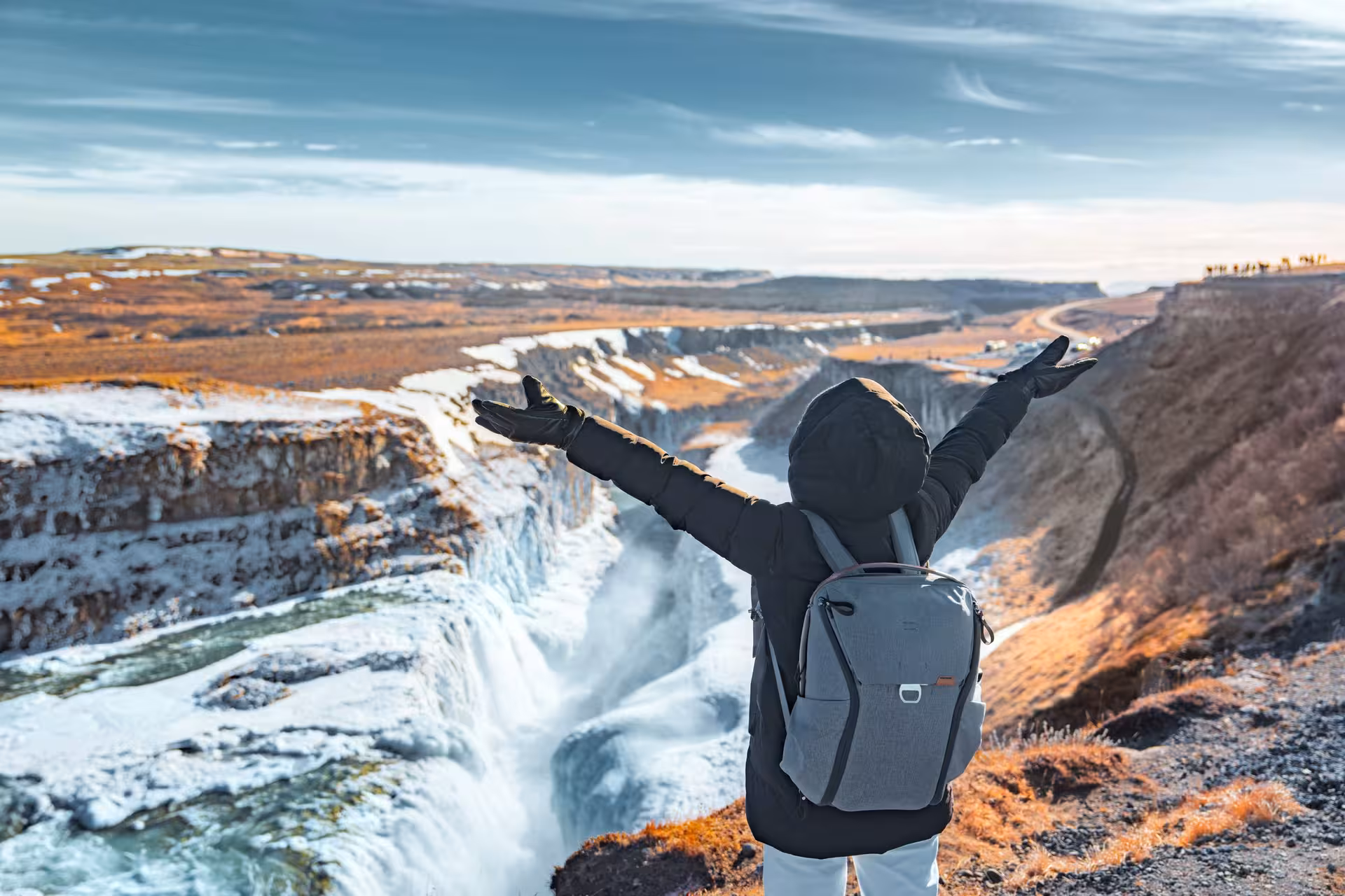 Traveler enjoys breathtaking view of Iceland's majestic Gullfoss waterfall during a 5-day Iceland stopover tour.