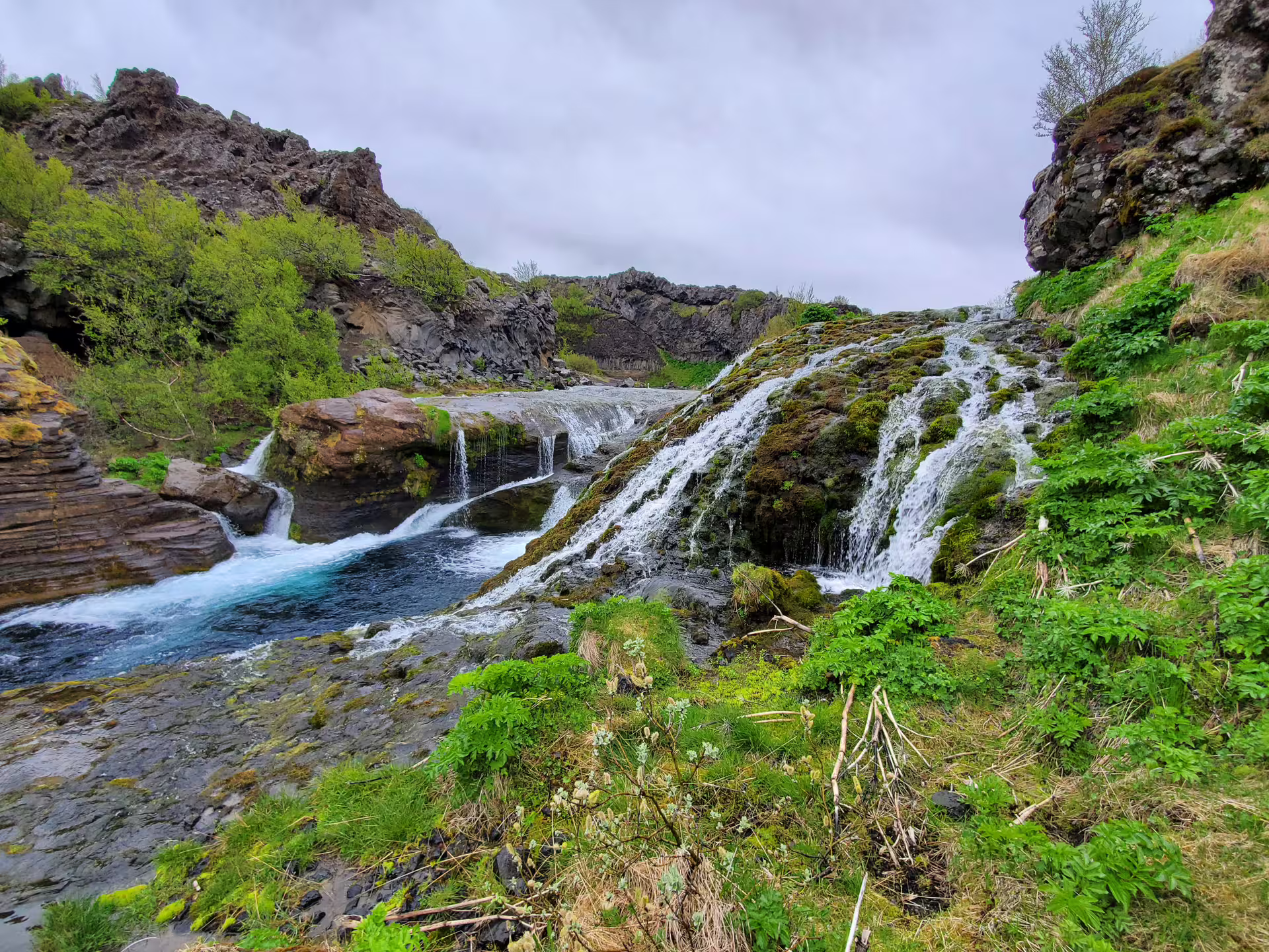 Lush green Iceland canyon with multiple hidden waterfalls and blue glacial river on an exclusive private super jeep day trip